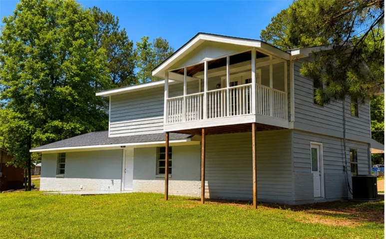 This charming home offers outdoor living with a spacious balcony overlooking a vibrant yard.