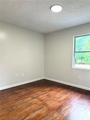 This airy room features durable wood flooring and a refreshing view of the outdoors.