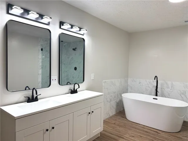 This spacious bathroom offers a double vanity and a luxurious soaking tub for ultimate relaxation.