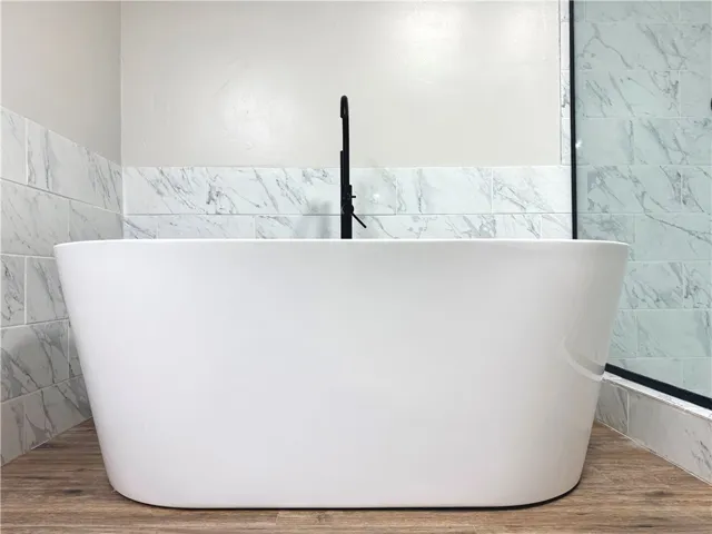 This primary bathroom features a freestanding soaking tub and elegant tile accents.