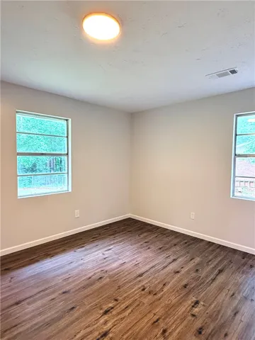 This bright room features durable vinyl plank flooring and abundant natural light from multiple windows.
