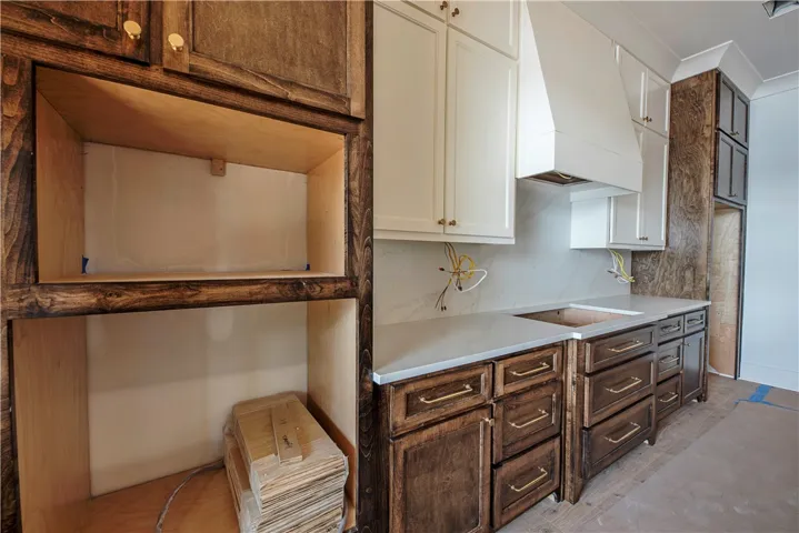 A newly installed kitchen showcases rich wood cabinetry and clean white countertops.