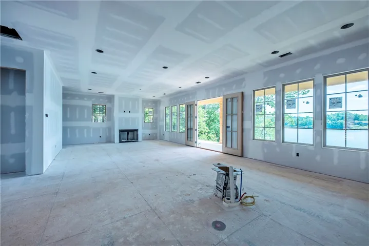 This living room provides an expansive view of the serene lake.