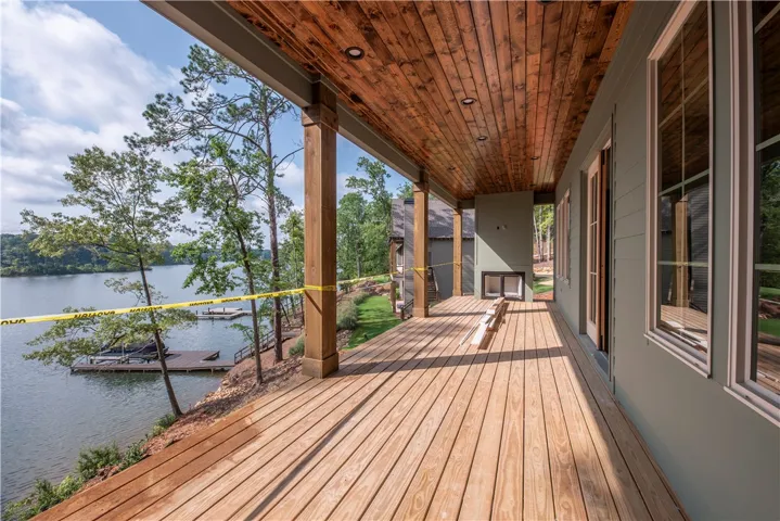 Lakeside views from this expansive wooden deck, perfect for outdoor relaxation and entertaining.