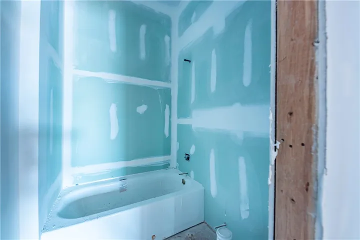 This bathroom under construction features a newly installed bathtub, ready for finishing touches.