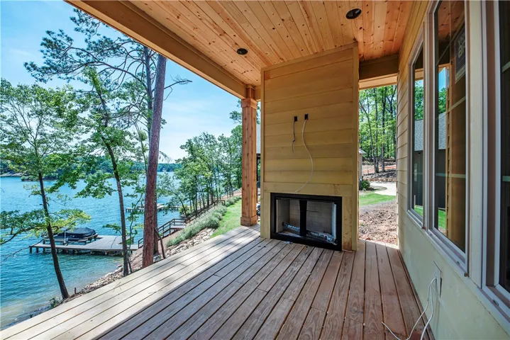 This tranquil lakeside retreat features an inviting patio with a fireplace, ideal for serene outdoor living.