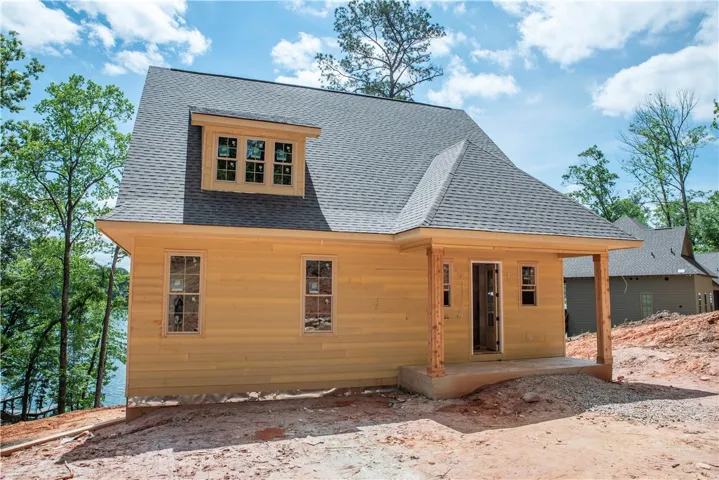 This newly constructed home features a classic asphalt shingle roof and durable wood siding, ready for its final touches.