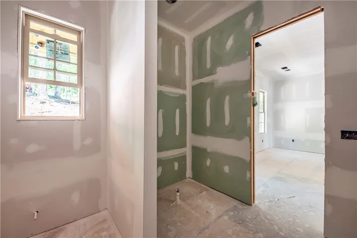 This interior space showcases a window with views of mature trees, ready for your personalized touch.