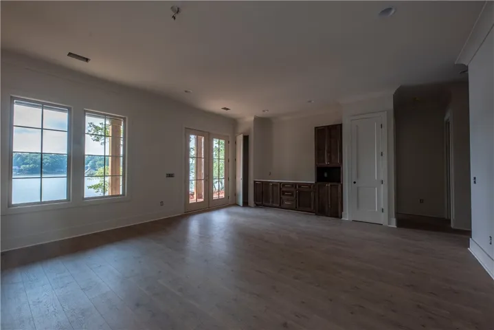Floor-to-ceiling lake views define this serene space, featuring sophisticated built-in cabinetry.