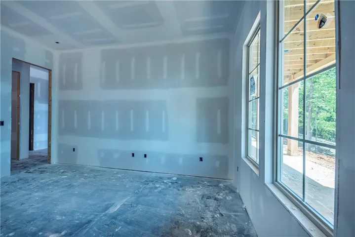 This bright space features large windows overlooking a peaceful wooded area, offering abundant natural light.