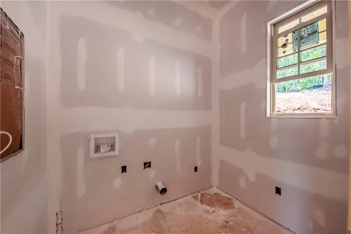 This laundry room awaits your personal touch, offering a blank canvas for future design.