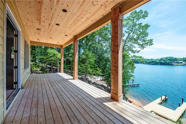 Enjoy tranquil water views from this expansive wooden deck, perfect for relaxation and outdoor living.