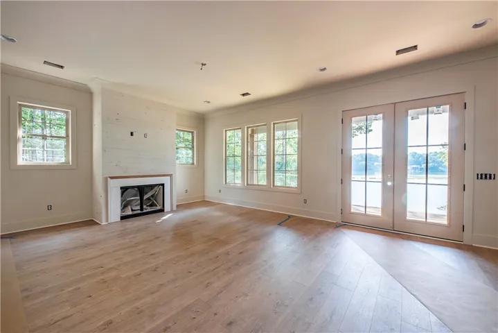 A spacious room with a cozy fireplace and direct access to waterfront views.
