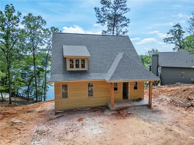 This newly constructed home features a classic gable roof and a charming front porch.
