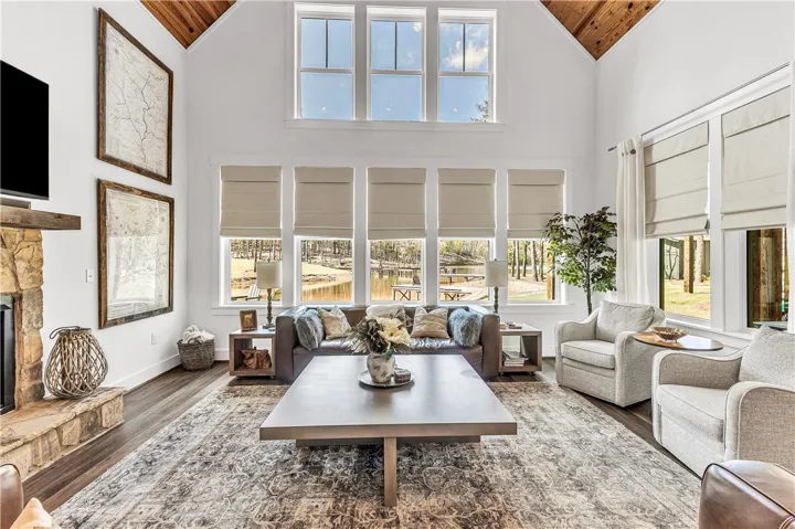 This airy living space offers soaring ceilings and expansive windows with picturesque views of the lake.