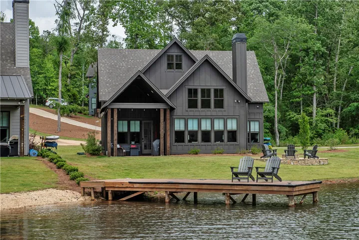 This charming lakeside dwelling features a private dock and a cozy outdoor patio, perfect for waterfront relaxation.