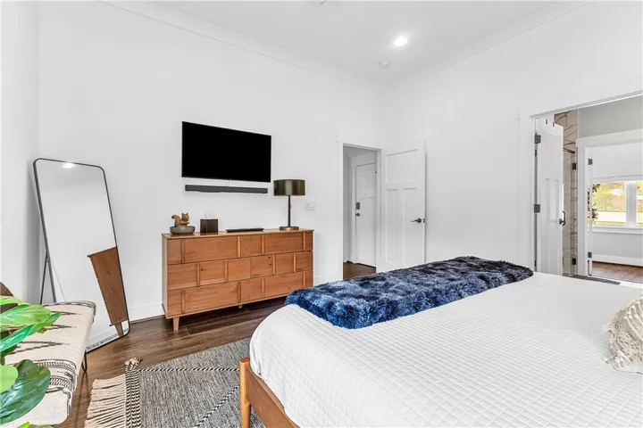 This spacious bedroom offers ample natural light and a clean, modern aesthetic.