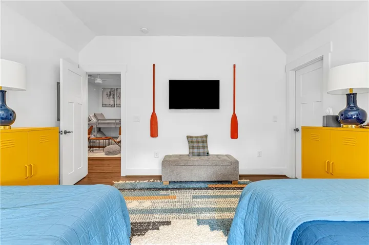 This inviting bedroom features vaulted ceilings and rich hardwood flooring, creating a cozy and spacious retreat.