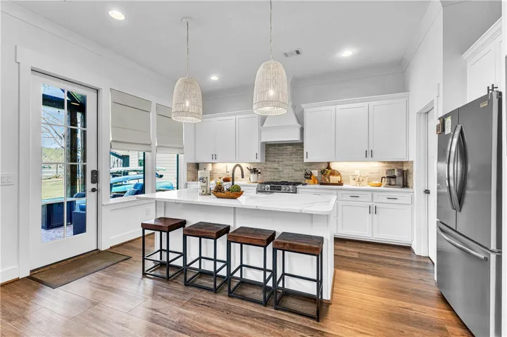 This bright kitchen features an island, ample cabinetry, and direct outdoor access.