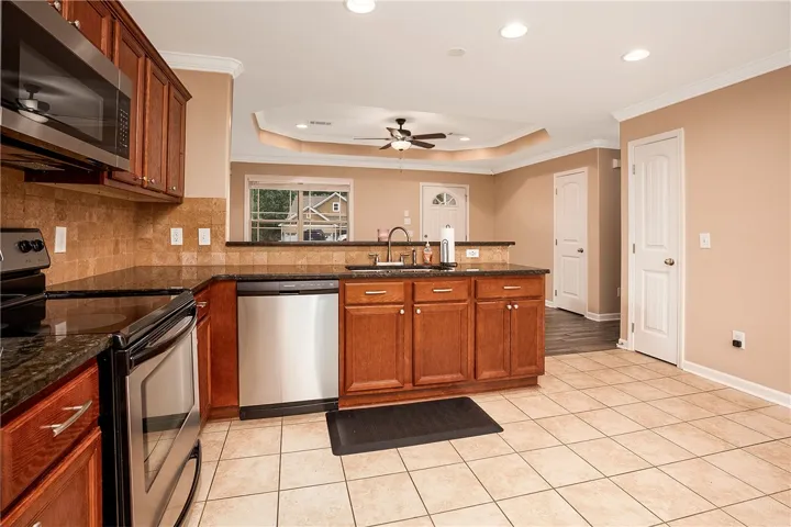 This kitchen features rich cabinetry, practical appliances, and an inviting layout for daily living.