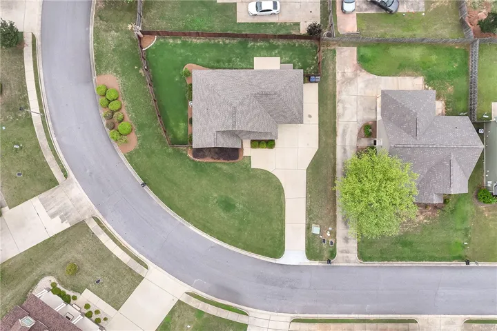 An aerial view captures the neighborhood with well-maintained lawns and paved driveways.