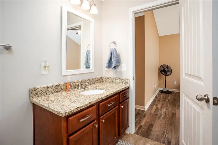 This bathroom features elegant granite counters and durable tile flooring, creating a polished and practical space.