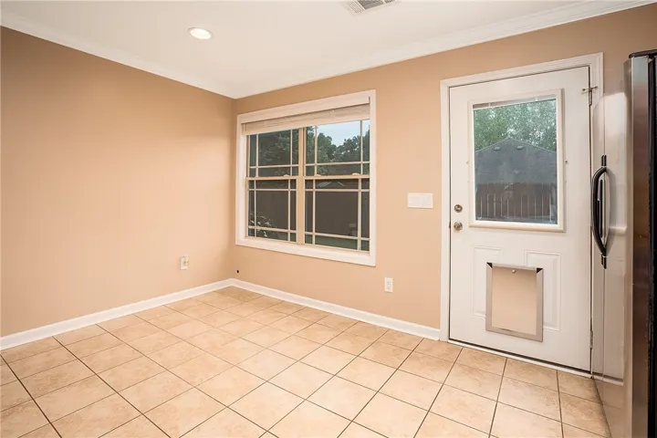 This bright space offers versatile living with direct outdoor access and durable tile flooring.