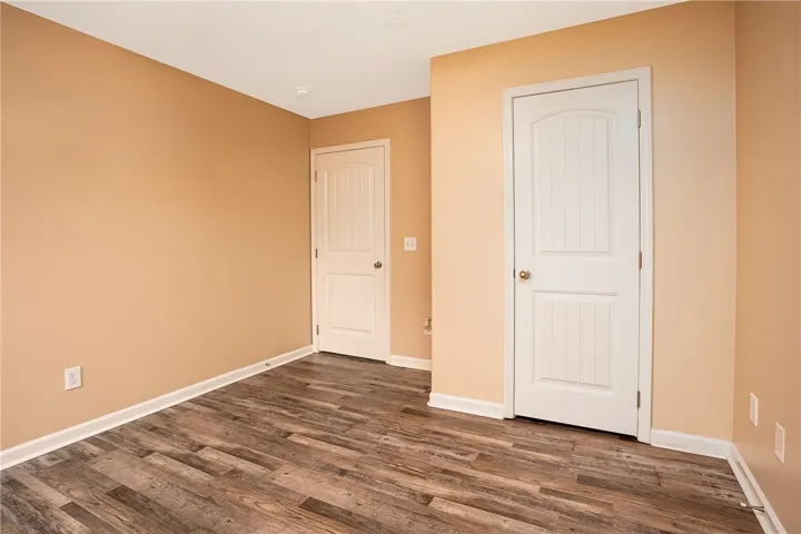 This versatile room features durable flooring and two classic doors, ready for personalized use.