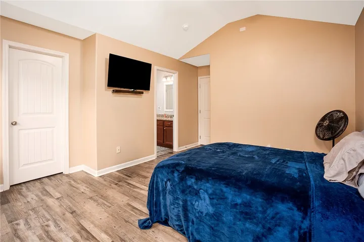This spacious bedroom offers comfortable living with elegant flooring and a connecting private bath.