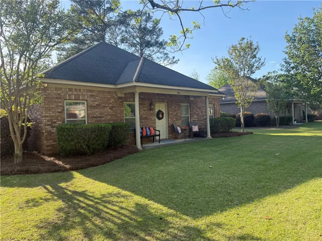 This charming brick home offers a welcoming facade with a well-maintained lawn and mature trees.