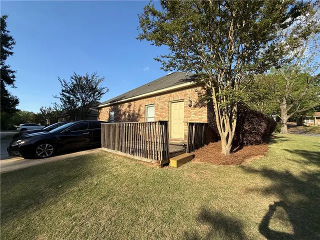 This charming brick home features a welcoming porch and well-maintained landscaping.