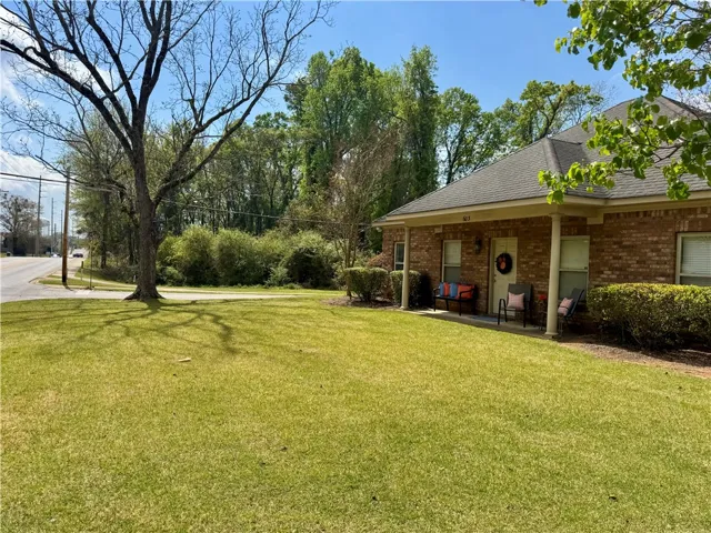 This charming residence features a classic brick exterior and a welcoming front porch, perfect for relaxation.