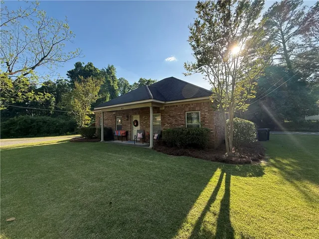 This charming brick home offers a welcoming facade with a cozy front porch and well-maintained landscaping.