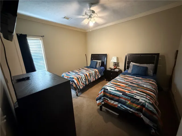 This spacious bedroom offers comfortable living with a neutral color palette and ample natural light.