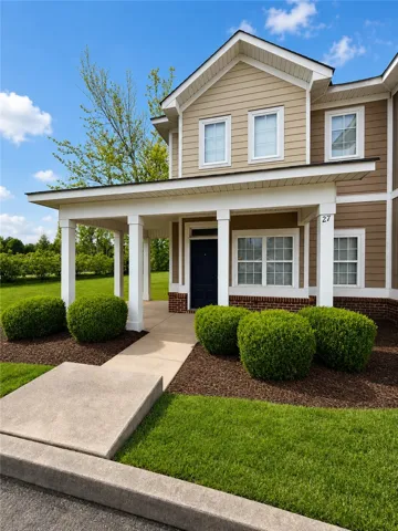 This inviting home presents a welcoming entrance with manicured landscaping and a covered porch.