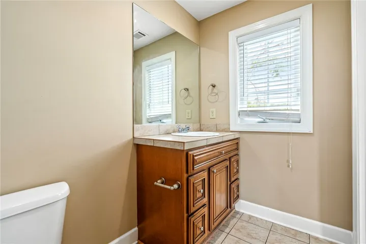 A well-appointed bathroom features a practical vanity with a sink and a mirror above.