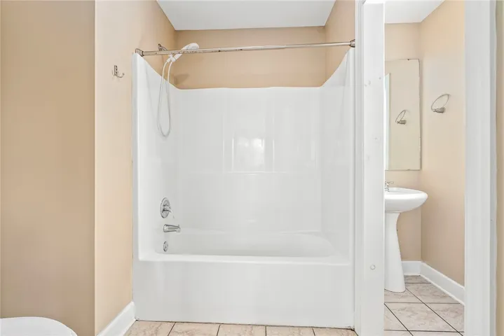 A classic bathtub and shower combination provides comfort and utility in this well-appointed bathroom.