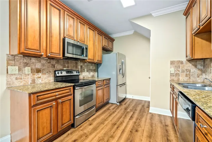 A well-appointed kitchen showcasing rich cabinetry, granite countertops, and modern stainless steel appliances.