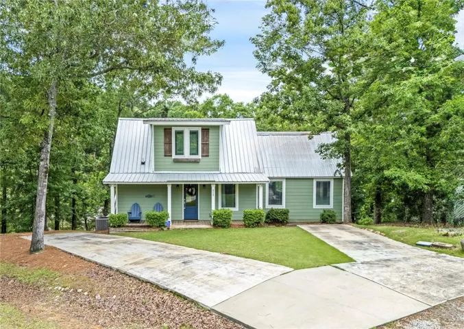 This charming home offers a tranquil retreat with mature trees and a welcoming facade.