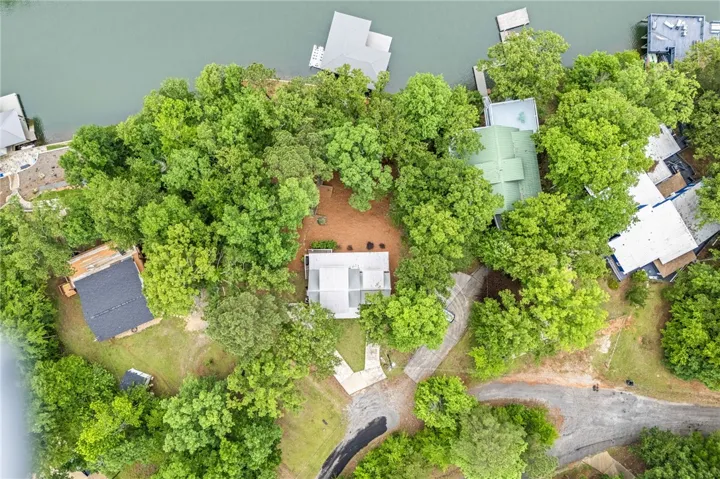 This aerial view showcases a tranquil waterfront property surrounded by lush greenery and private docks.