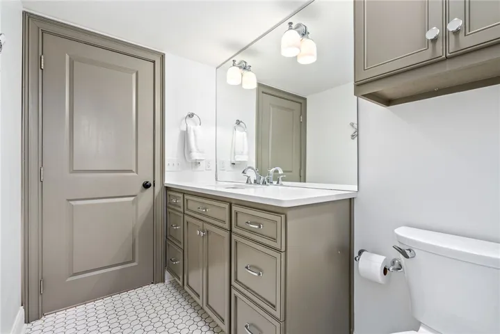 This clean and bright bathroom features elegant cabinetry and modern fixtures, creating a refreshing space.