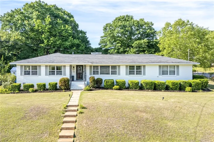 This charming residence features a well-maintained lawn and classic architecture.
