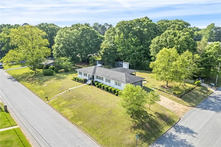 Spacious lot, surrounded by mature trees and lush greenery.
