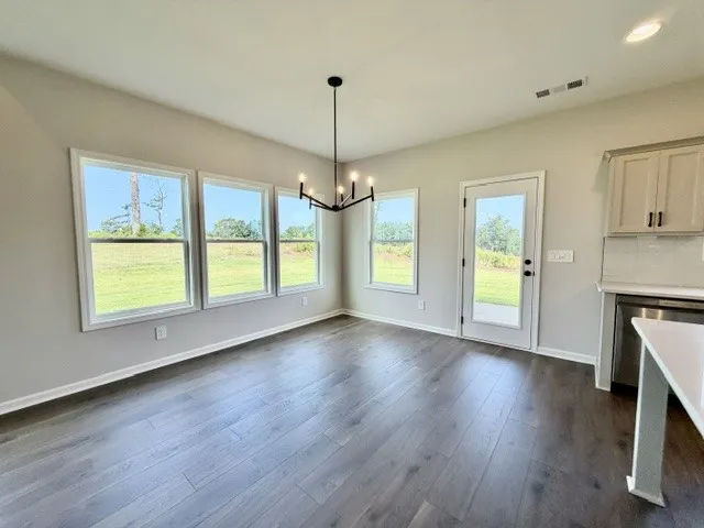 Luminous dining area showcasing ample natural light and a modern light fixture.