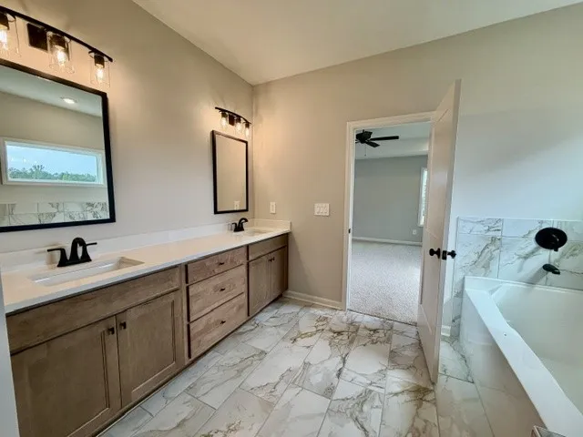 Dual vanities and a deep soaking tub complete this well-appointed primary bathroom.