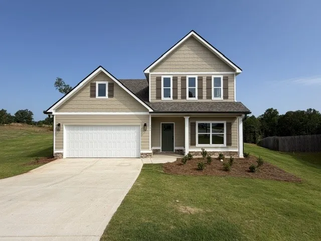 A newly constructed residence showcasing classic shutters and a well-maintained yard.