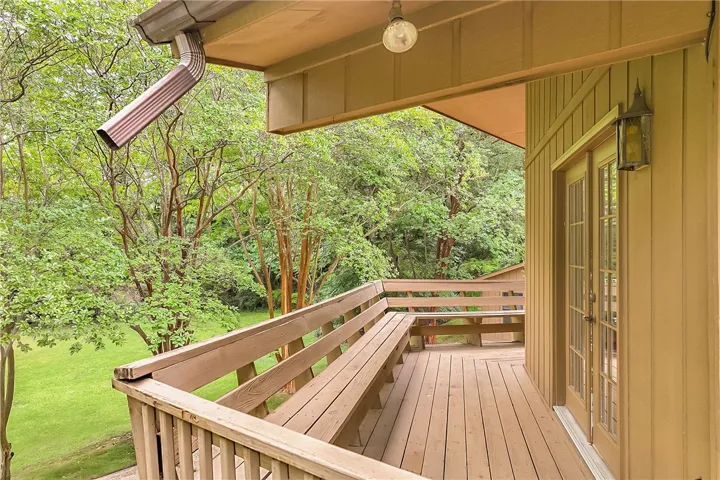 A spacious wooden deck provides a tranquil overlook of the surrounding natural landscape.