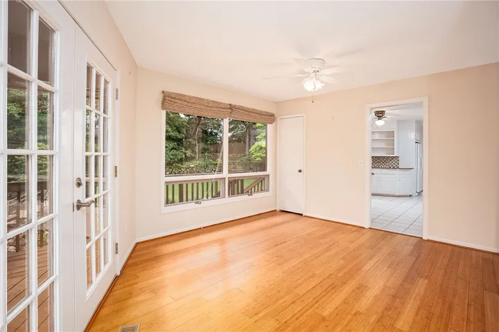 Natural light floods this living area through broad windows and glass-paned French doors.