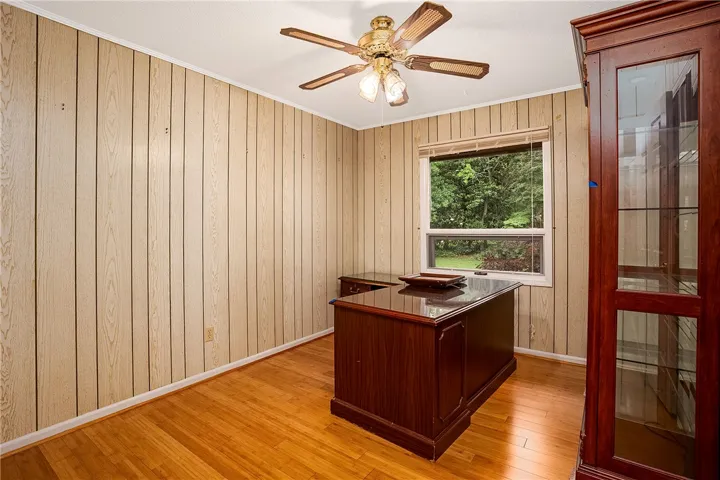 Well-lit study with wood paneling and natural light, perfect for focused work.