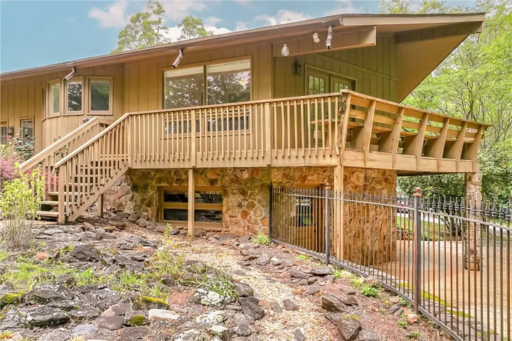A split-level residence with extensive deck space and robust stone foundation, perfect for outdoor living.